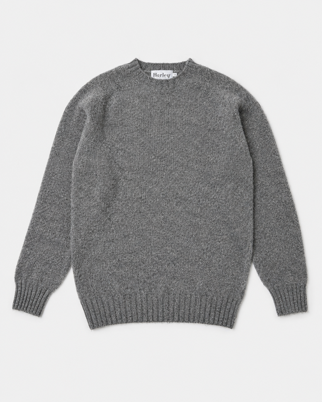 A classic gray knit crewneck sweater with ribbed cuffs and hem, laid flat against a light gray background. The brand name 'Harris' is visible on the inner neck label.
